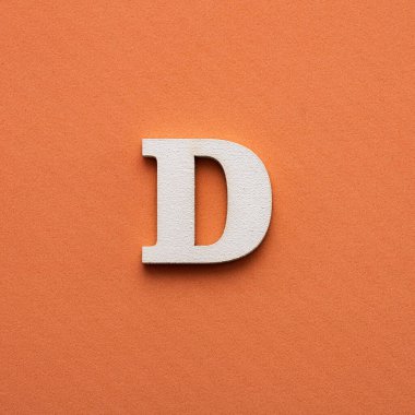 Alfabe harfi D - pembe arkaplanda beyaz ahşap harf
