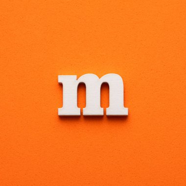 Beyaz küçük harf m turuncu köpüklü arka plan