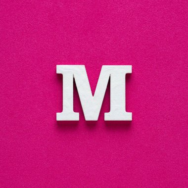 Alphabet letter M - White wooden letter on rhodamine red background