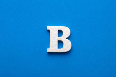 Alphabet letter B - White wooden letter on blue foamy background