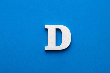 Alphabet letter D - White wooden letter on blue foamy background