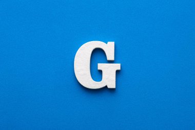 Letter G uppercase - White wood font on blue foamy background