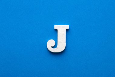 Alphabet letter J - White wooden letter on blue foamy background