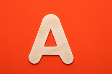 Alphabet letter A - White wood piece on orange foamy background