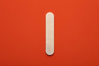 Alphabet letter I - White wood piece on orange foamy background
