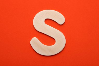 Alphabet letter S - White wood piece on orange foamy background
