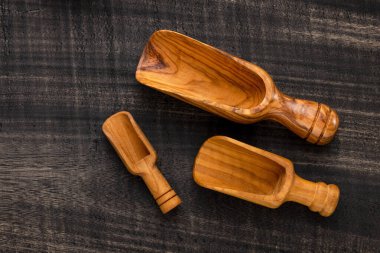 Different types of wooden scoop on dark rustic table - Kitchen accessories