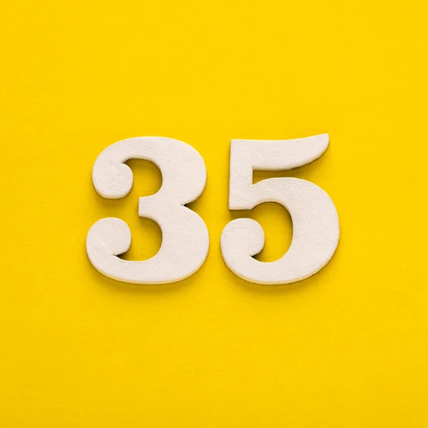 Number 35 - Two figures in white on a yellow background
