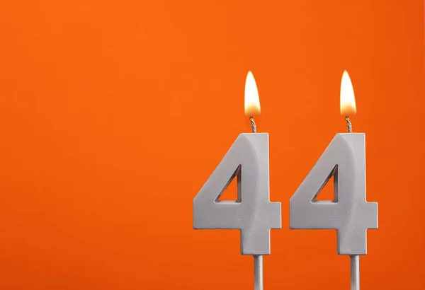 Candle number 44 - Birthday in orange background