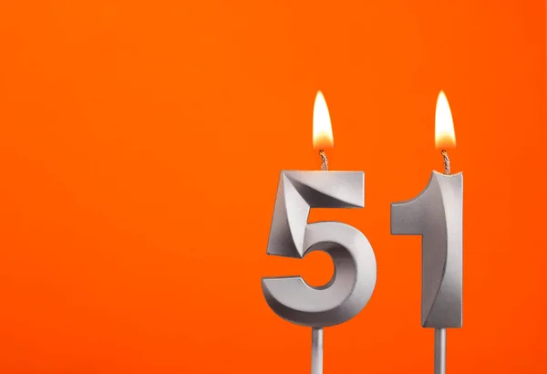 Number 51 - Silver Anniversary candle on orange background
