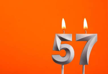 57 Numara - Turuncu arka planda gümüş yıldönümü mumu