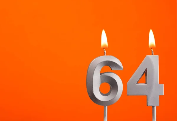 Candle number 64 - Birthday in orange background