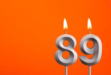 89 Numara - Turuncu arka planda gümüş yıldönümü mumu