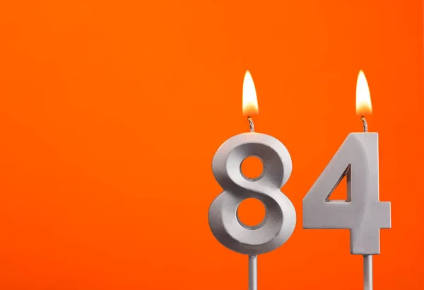 蜡烛84号 橙色背景的生日 — 图库照片