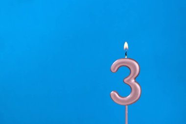 3 numara - Mavi köpüklü arka planda yanan yıldönümü mumu