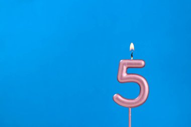 5 numara - Mavi köpüklü arka planda yanan yıldönümü mumu