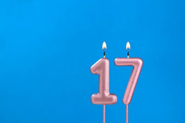 17 Numara - Mavi köpüklü arka planda yanan yıldönümü mumu
