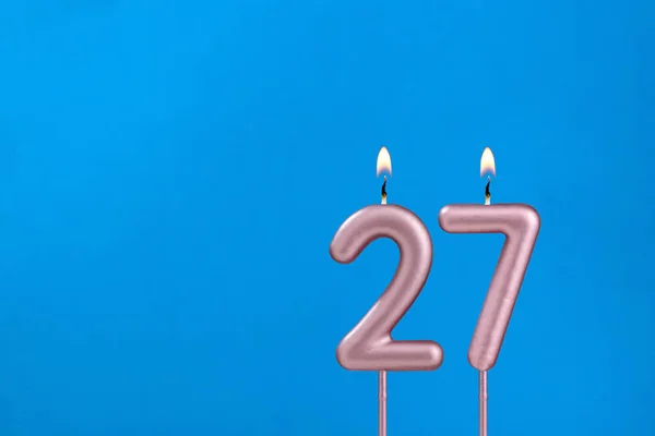 27番 青い泡の背景に燃える記念日のろうそく — ストック写真