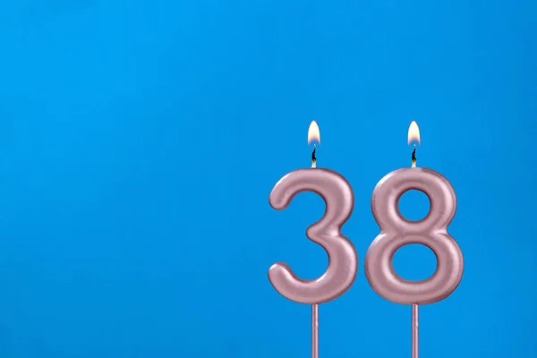 38号 在蓝色泡沫背景下燃点周年蜡烛 — 图库照片