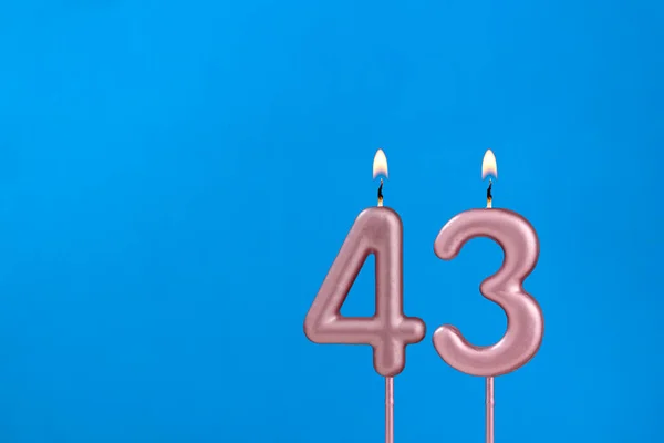 43番 青い泡の背景に燃える記念日のろうそく — ストック写真