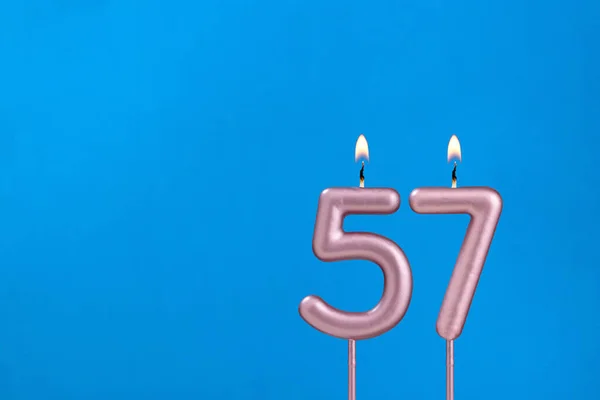 57番青い泡の背景に燃える記念日のろうそく — ストック写真