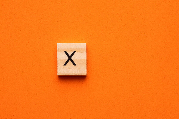 Алфавит заглавная буква X на деревянной квадратной плитке - Оранжевый пенный фон
