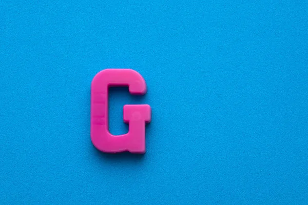 Πλαστικό Ροζ Γράμμα Κεφαλαίο Μπλε Αφρώδες Φόντο — Φωτογραφία Αρχείου