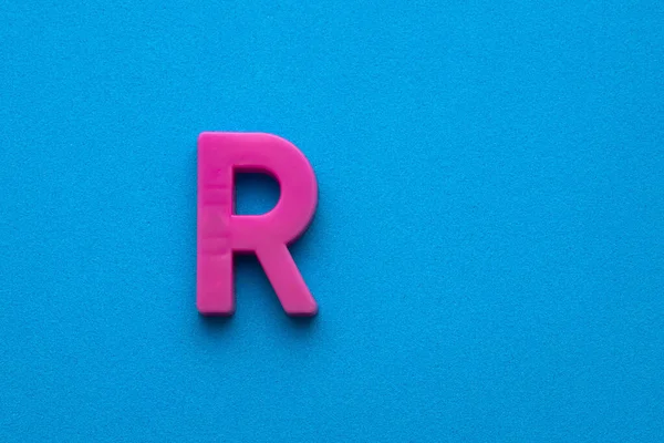 Αλφάβητο Γράμμα Ροζ Πλαστικό Κομμάτι Μπλε Αφρώδες Φόντο — Φωτογραφία Αρχείου