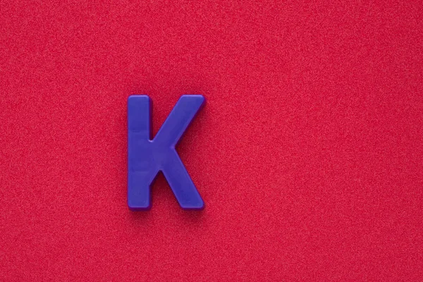Alphabet Buchstabe Violett Gefärbtes Plastikstück Auf Rotem 032 Schaumigem Hintergrund — Stockfoto