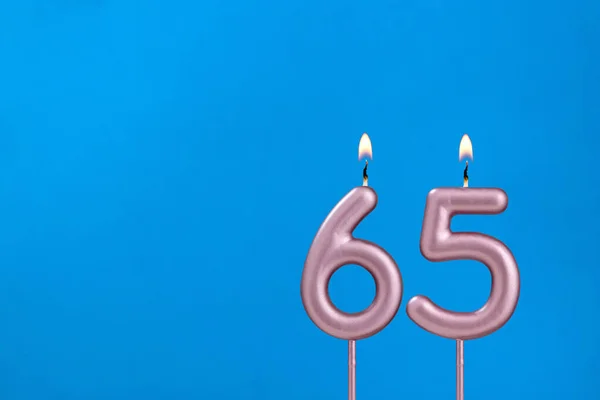 65号 在蓝色泡沫背景下燃点周年蜡烛 — 图库照片