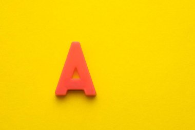 Şeftali rengi plastik harf Sarı köpüklü arka planda büyük bir harf