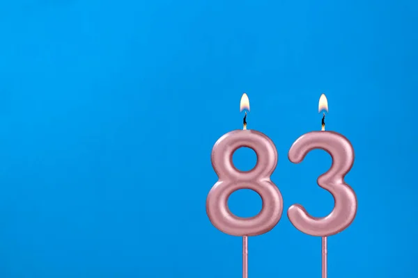 83番 青い泡の背景に燃える記念日のろうそく — ストック写真