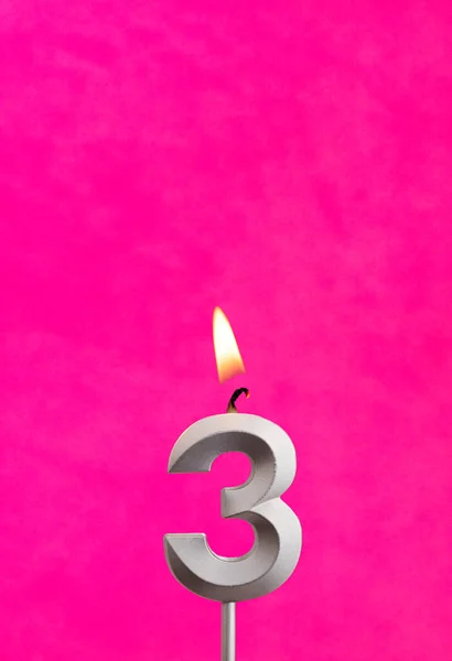 Candle 3 with flame - Silver anniversary candle on a fuchsia background