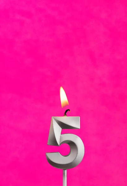 Candle 5 with flame - Silver anniversary candle on a fuchsia background