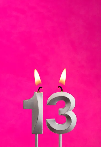 Candle 13 with flame - Silver anniversary candle on a fuchsia background