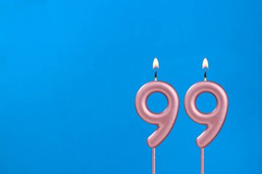 99 Numara - Mavi köpüklü arka planda yanan yıldönümü mumu