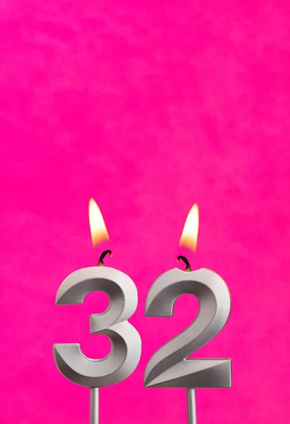 Candle 32 with flame - Silver anniversary candle on a fuchsia background