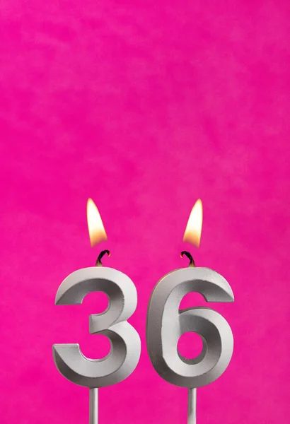 Candle 36 with flame - Silver anniversary candle on a fuchsia background