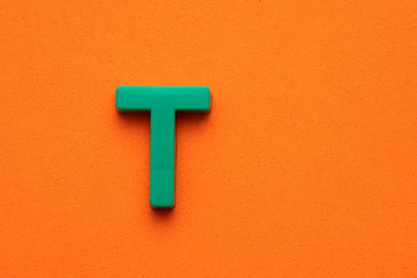 Αλφάβητο Γράμμα Πράσινο Πλαστικό Κομμάτι Πορτοκαλί Αφρώδες Φόντο — Φωτογραφία Αρχείου