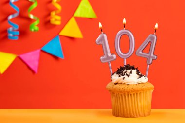 104 numaralı mumlu doğum günü pastası kiraz çiçekli parlak turuncu arka plan