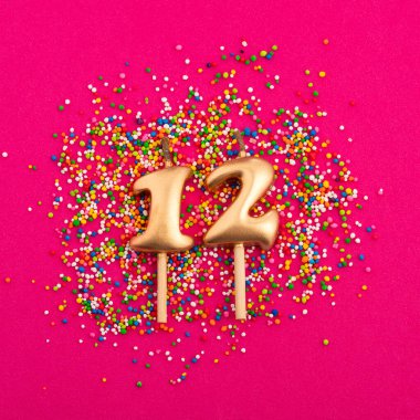 Doğum günü mumu numara 12 - rodamine kırmızı arka planda yıldönümü kutlaması