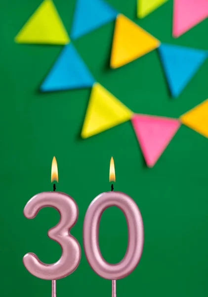 30番の誕生日キャンドル 緑の背景で記念日のお祝い — ストック写真