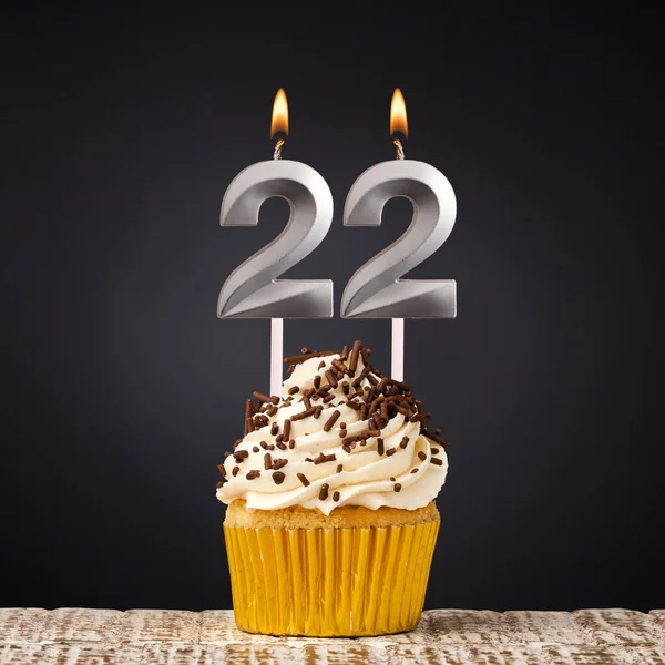 22番のキャンドル付きの誕生日カップケーキ 暗い背景でお祝い — ストック写真