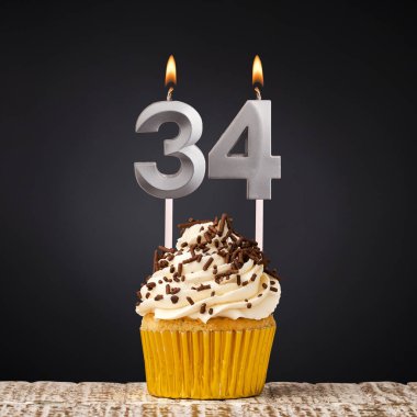 34 numaralı mumlu doğum günü pastası - Karanlık arka planda kutlama