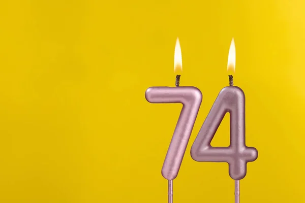 带有黄色豪华背景的火焰生日卡片的第74号烛台 — 图库照片