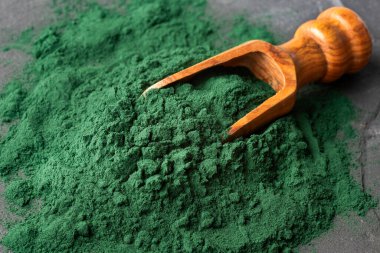 Tahta kaşıkta organik spirulina tozu.
