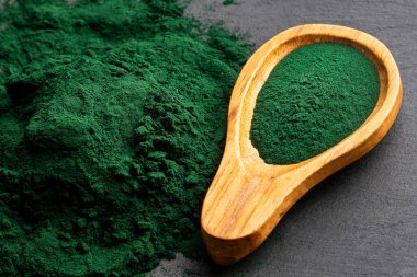 Tahta kaşıkta organik spirulina tozu.