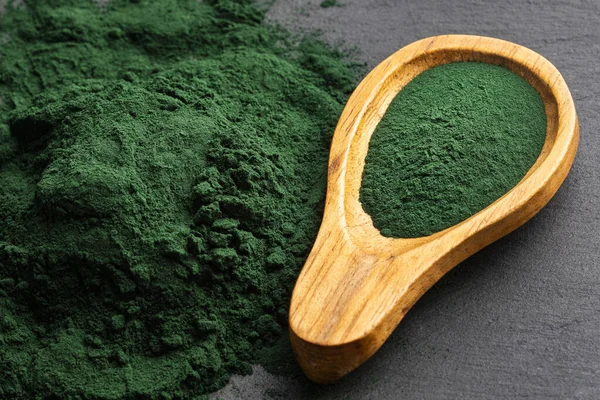 Tahta kaşıkta organik spirulina tozu.