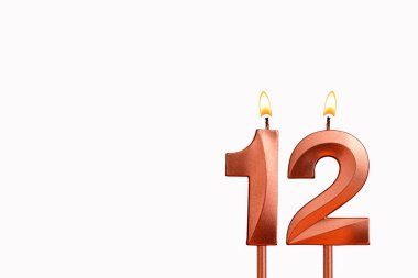 Doğum günü için beyaz arkaplanda 12 numaralı mumu yakıyorum
