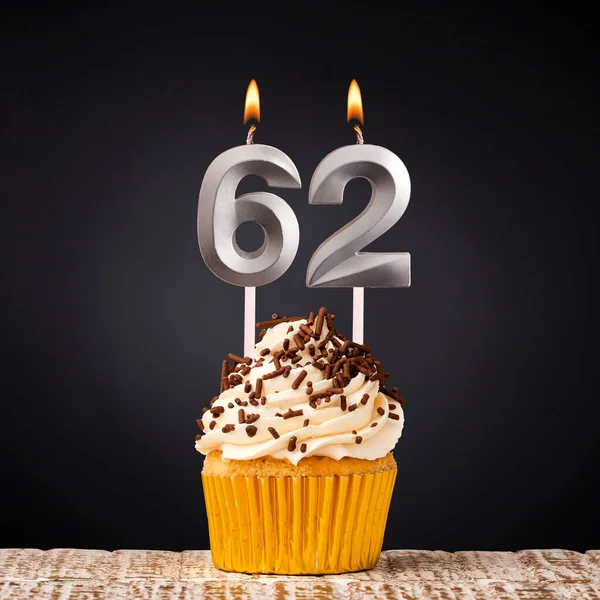 stock image birthday cupcake with number 62 candle - Celebration on dark background